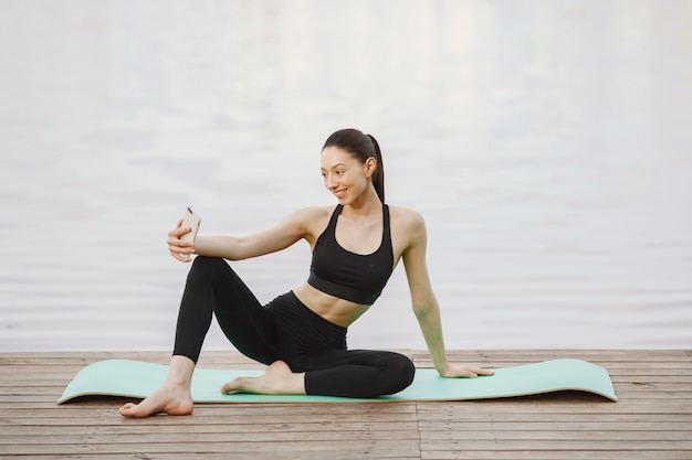 Mujer practicando yoga avanzado por el agua