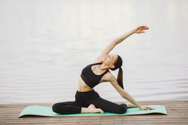 Mujer practicando yoga avanzado por el agua