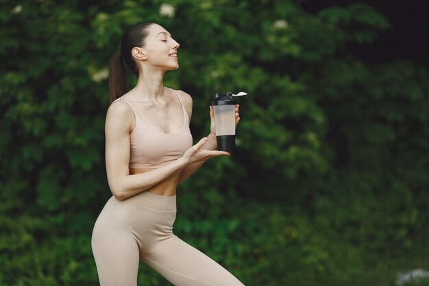 Mujer practicando yoga avanzado en un parque de verano