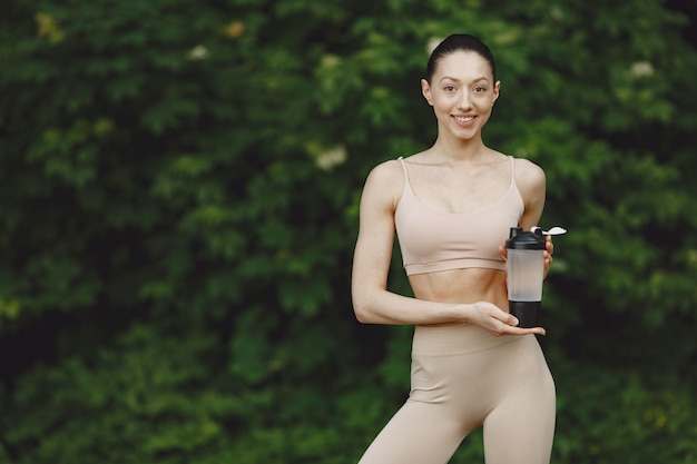 Mujer practicando yoga avanzado en un parque de verano