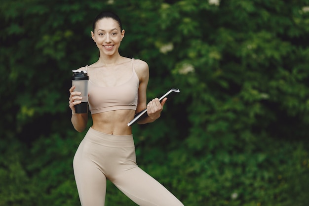 Mujer practicando yoga avanzado en un parque de verano