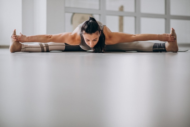 Mujer practicando yoga en el gimnasio sobre una estera
