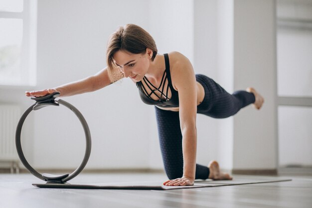 Mujer practicando yoga en el gimnasio sobre una estera