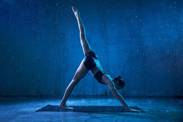 Mujer practicando yoga bajo la lluvia