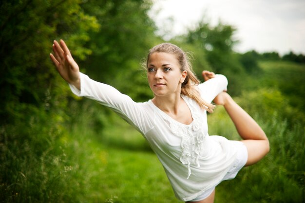 Mujer practicando yoga en la naturaleza