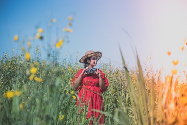Mujer en un prado con una cámara de fotos