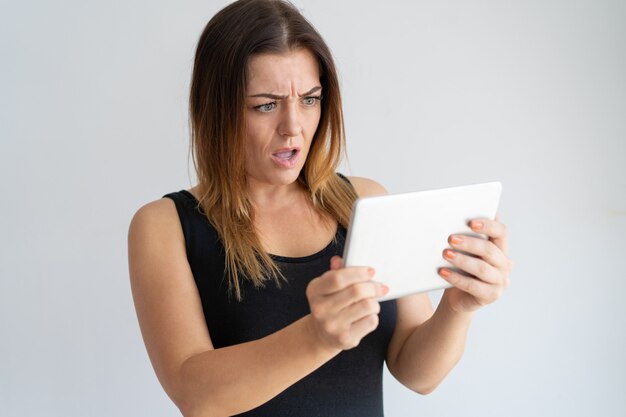 Mujer preocupada mirando la pantalla de la tableta