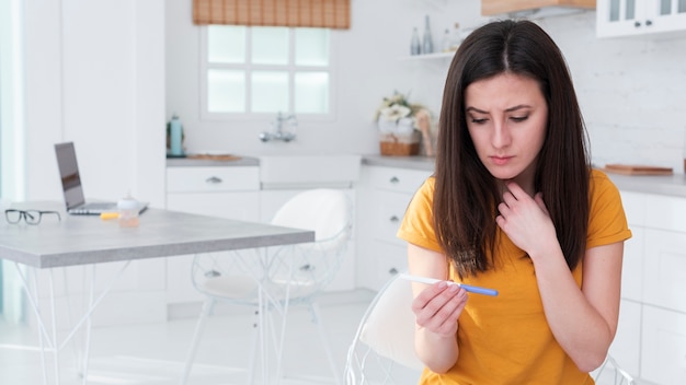 Mujer preocupada con prueba de embarazo