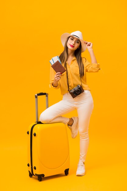 Mujer preparada para vacaciones con equipaje y elementos esenciales de viaje
