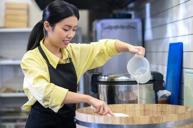 Mujer preparando arroz para sushi en la cocina del restaurante