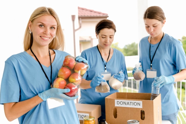 Mujer preparando cajas con comida para donación