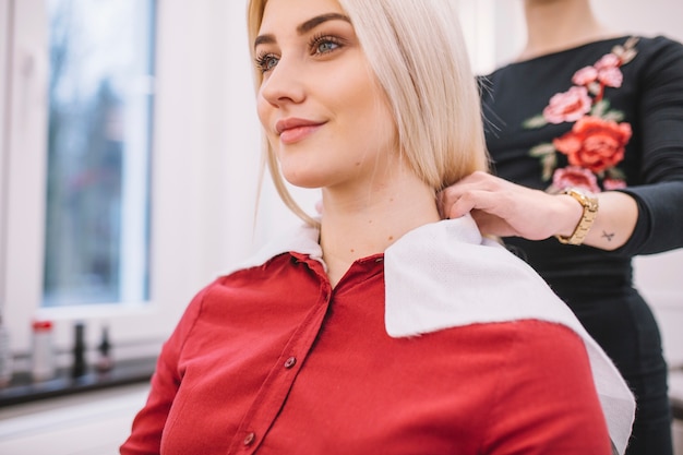 Foto gratuita mujer preparando a chica para el procedimiento de corte de pelo