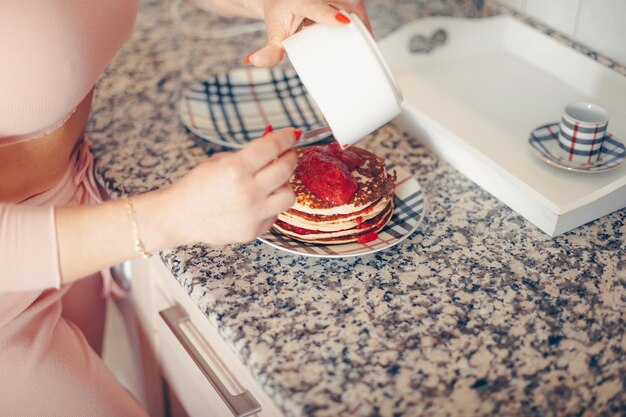 Mujer preparando crepe en cocina. .