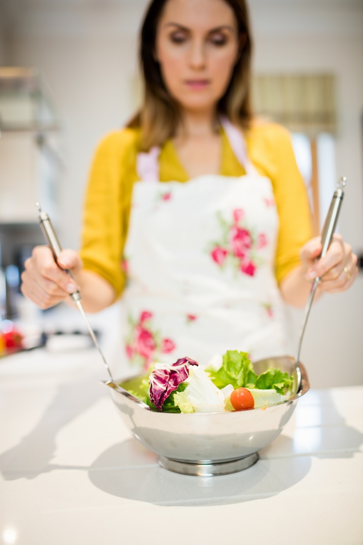 Foto gratuito mujer preparando ensalada en la cocina