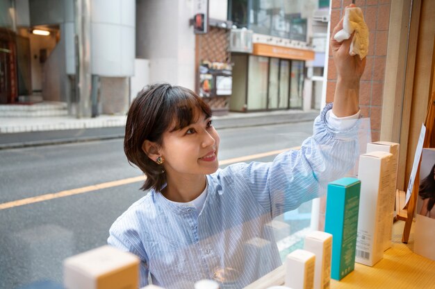 Mujer preparando el escaparate de una peluquería japonesa