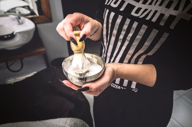 Mujer preparando espuma en peluquería