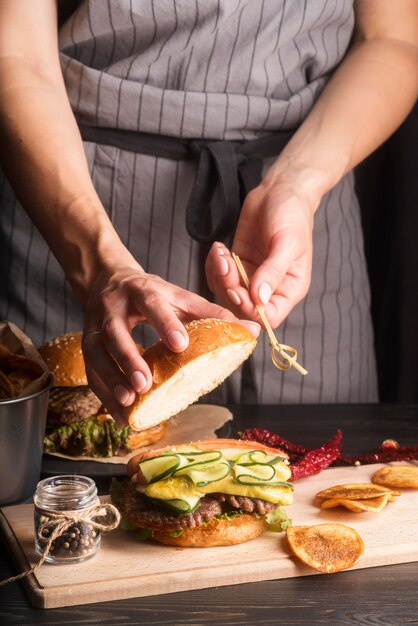 Mujer preparando hamburguesas y papas fritas close-up