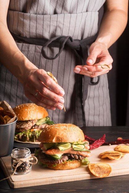 Mujer preparando hamburguesas y papas fritas