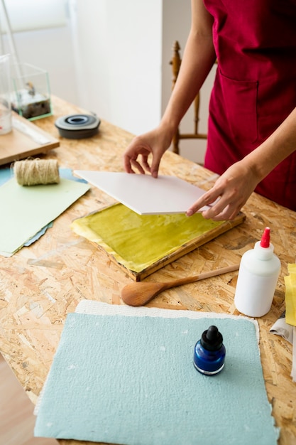 Mujer preparando papel hecho a mano en el escritorio de madera
