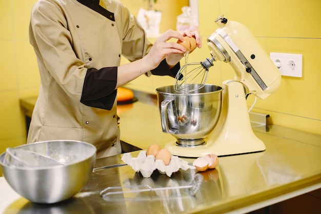 Mujer preparando pasteles. Pastelero con abrigo.