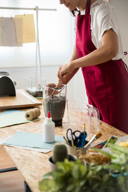 Mujer preparando pulpa de papel en la licuadora