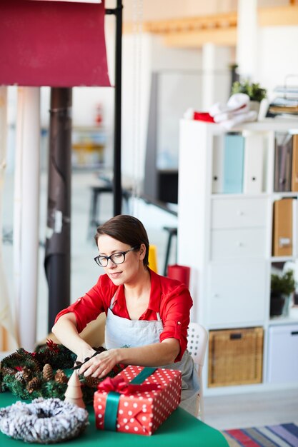 Mujer preparando regalos y decoración navideña