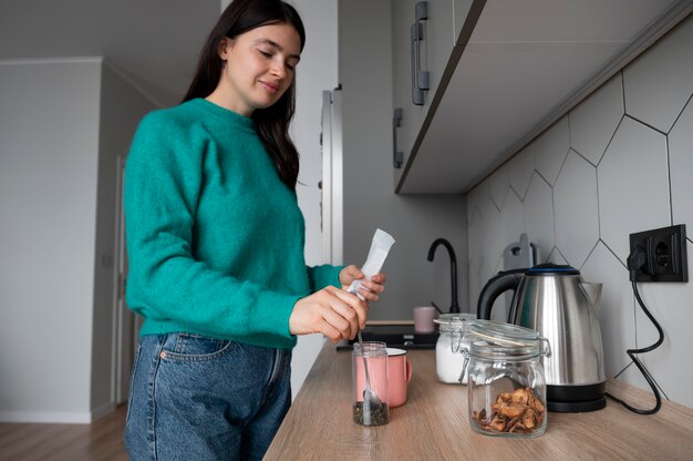 Mujer preparando té en casa durante la cuarentena