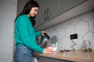 Foto gratuita mujer preparando té en casa durante la cuarentena