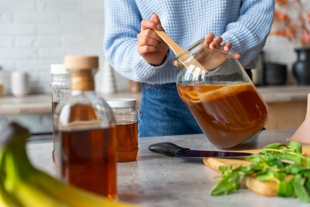 Mujer preparando vista frontal de kombucha