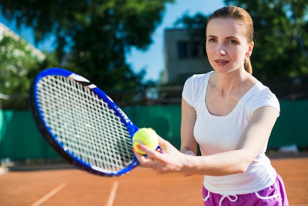 Mujer preparándose para servir en el tenis