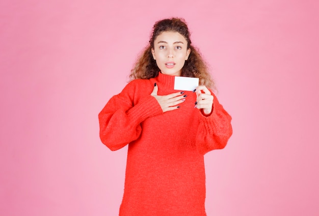 mujer presentando su tarjeta de presentación o recibiendo a otras personas.