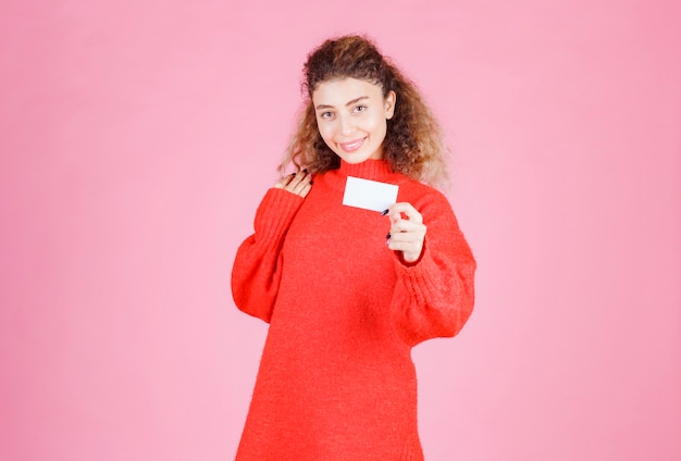 mujer presentando su tarjeta de presentación o recibiendo a otras personas.