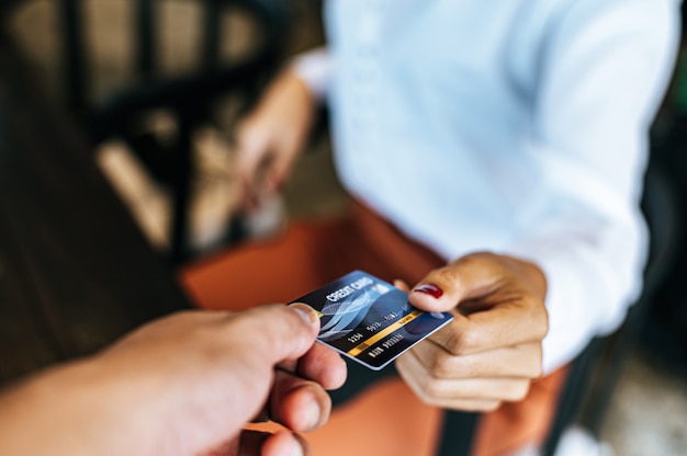 Mujer presentando tarjeta de crédito para pagar bienes