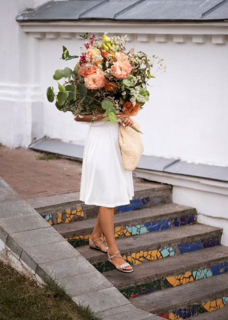 Foto gratuita mujer, en, el, primavera, tenencia, ramo de flores