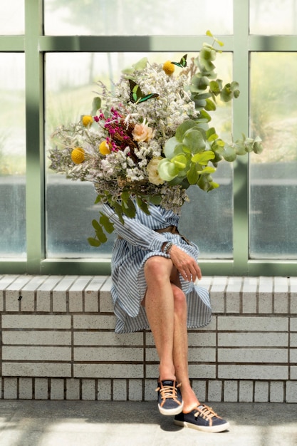 Foto gratuita mujer, en, el, primavera, tenencia, ramo de flores