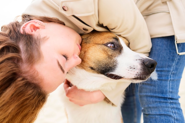 Mujer de primer plano abrazando a su lindo perro