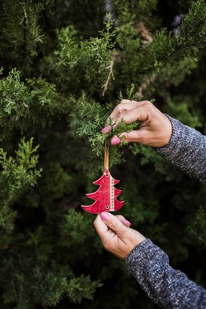 Mujer de primer plano con adornos navideños en forma de árbol