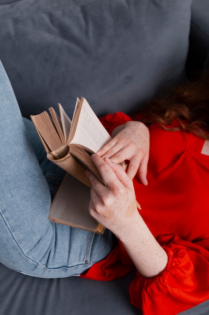 Mujer de primer plano de alto ángulo en sofá leyendo