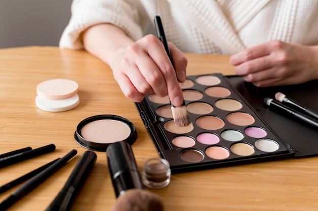 Mujer de primer plano aplicando sombra de ojos