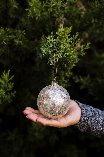 Mujer de primer plano con árbol de Navidad y globo