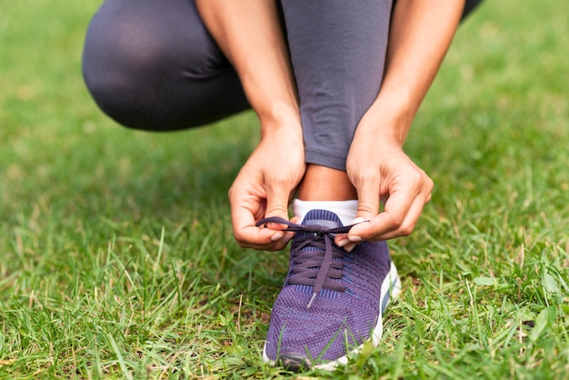 Mujer de primer plano atando sus cordones