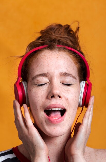 Mujer de primer plano con auriculares y boca abierta