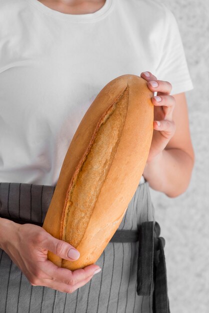 Mujer de primer plano con baguette fresca