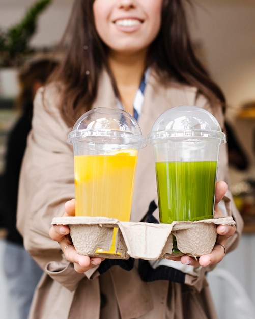 Mujer de primer plano con bebidas frescas para llevar