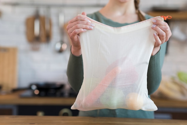 Foto gratuita mujer de primer plano con bolsa reutilizable con comestibles