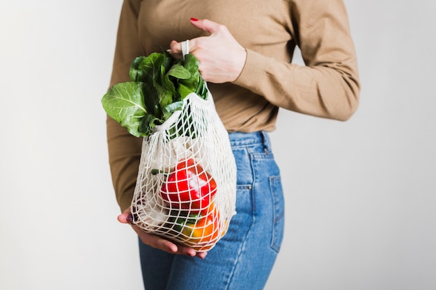 Mujer de primer plano con bolsa de supermercado reutilizable