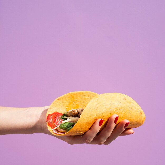 Mujer de primer plano con burrito y fondo morado