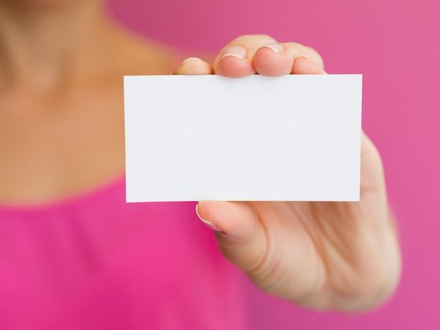 Mujer de primer plano con camisa rosa y tarjeta blanca