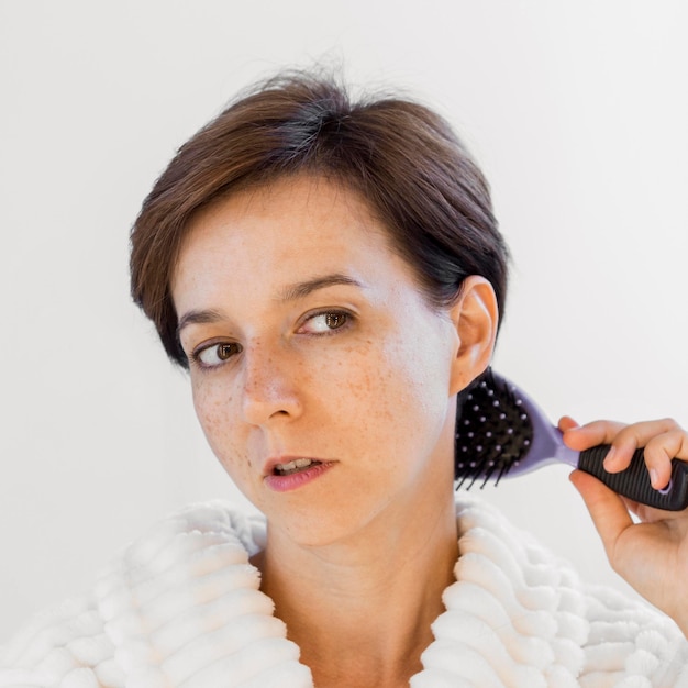 Mujer de primer plano cepillando su cabello