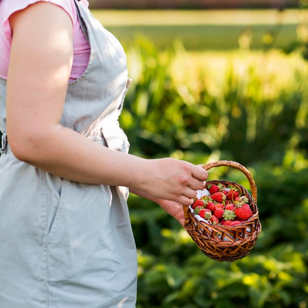 Mujer de primer plano con cesta de frutas